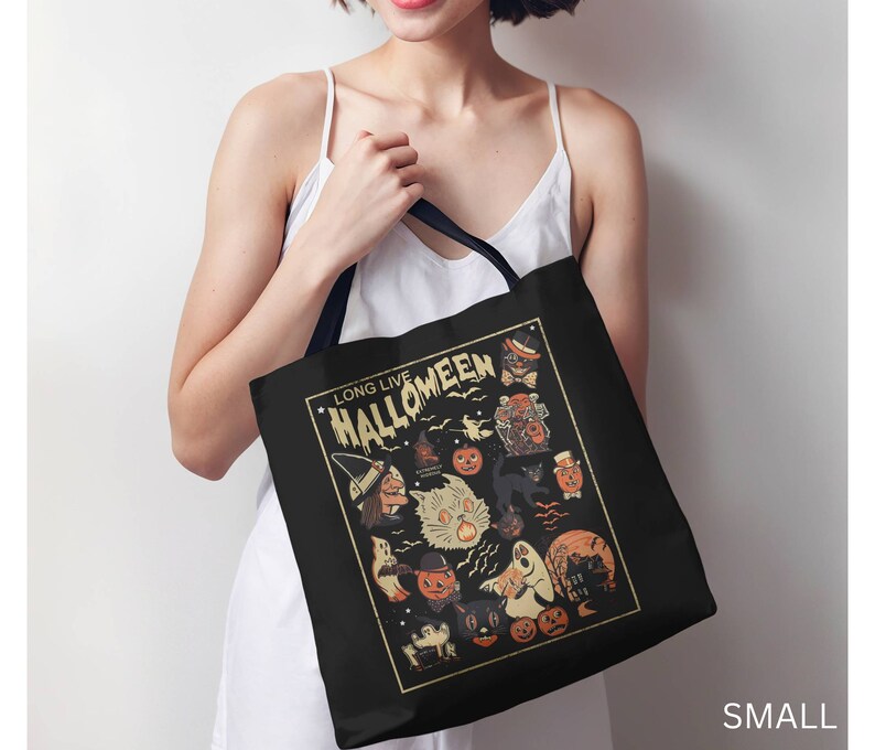 May include: A black tote bag with a white design featuring a vintage Halloween illustration. The design includes a witch, a cat, a ghost, and pumpkins. The text "Long Live Halloweeen" is printed in a vintage font.