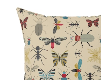 May include: A beige throw pillow with a repeating pattern of colorful butterflies and insects. The insects are drawn in a stylized, graphic style.