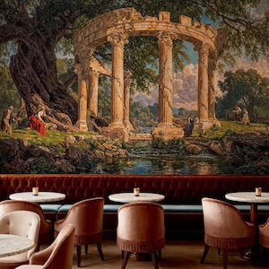 Op de afbeelding: Een gedetailleerde muurschildering toont een klassieke ruïne met zuilen, een rivier en figuren in een landschap. De muurschildering bevindt zich boven een bordeauxrode fluwelen bank met kleine ronde tafels en roze fluwelen stoelen.