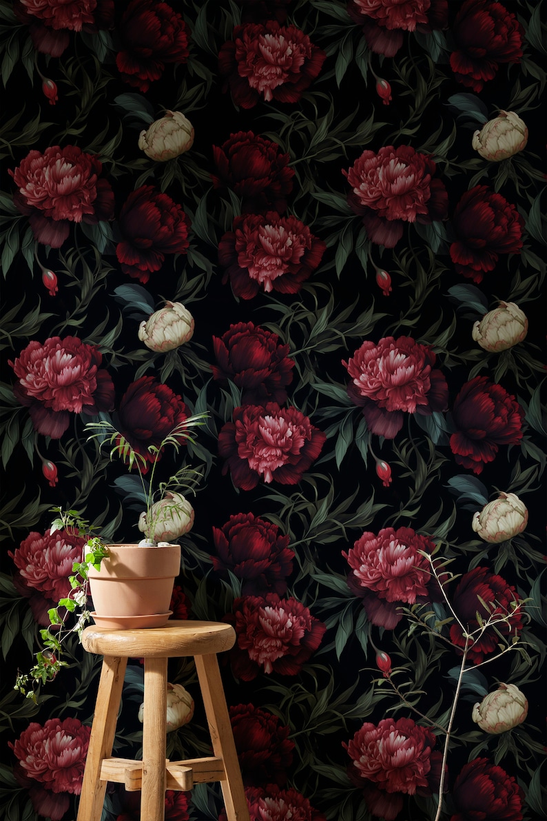 May include: A dark floral wallpaper with a repeating pattern of red and pink peonies, green leaves, and white buds. A small potted plant sits on a wooden stool in front of the wallpaper.