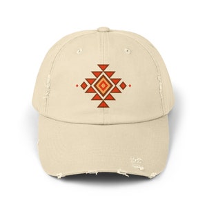 Puede incluir: Una gorra de béisbol desgastada de color beige con un patrón geométrico rojo, naranja y amarillo en la parte delantera.