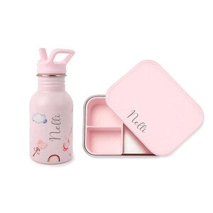May include: A pink water bottle and lunchbox set. The water bottle has a flip-top lid and is decorated with clouds, hearts, and a rainbow. The lunchbox is rectangular with a pink lid and a stainless steel interior. Both items have the name "Nelli" printed on them.