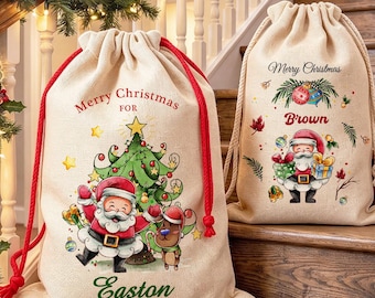 Pode incluir: Duas sacolas de presente em lona bege com cordões vermelhos e creme. A sacola maior apresenta o Papai Noel, uma árvore de Natal e o texto Merry Christmas FOR Easton. A menor mostra o Papai Noel com presentes e Merry Christmas Brown.