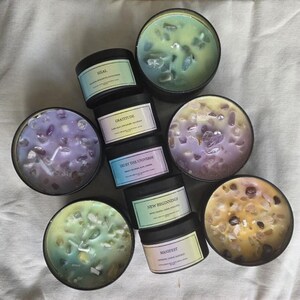 Pu&ograve; includere: Assortimento di otto piccoli barattoli di vetro per candele con cera di vari colori e cristalli incorporati. I barattoli sono etichettati con diverse affermazioni, tra cui "Guarire", "Gratitudine", "Fidati dell'universo", "Nuovi inizi", "Manifesta", e altro ancora.