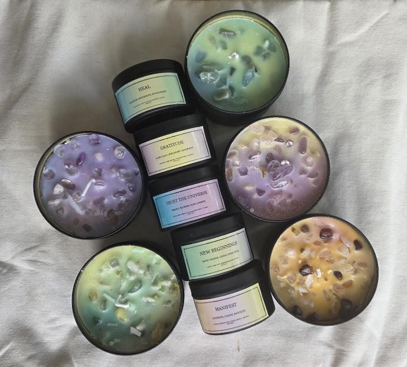 Pu&ograve; includere: Assortimento di otto piccoli barattoli di vetro per candele con cera di vari colori e cristalli incorporati. I barattoli sono etichettati con diverse affermazioni, tra cui "Guarire", "Gratitudine", "Fidati dell'universo", "Nuovi inizi", "Manifesta", e altro ancora.