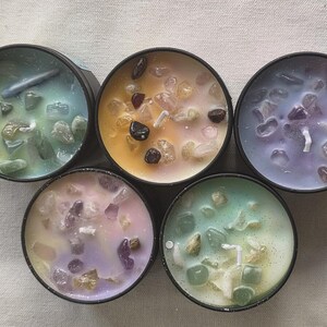 Pu&ograve; includere: Sei piccole candele con cera di diversi colori e cristalli incorporati. Le candele sono in contenitori neri.