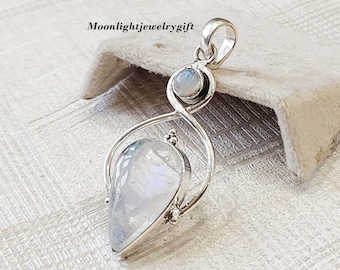 May include: A silver pendant with a teardrop-shaped moonstone and a smaller round moonstone. The pendant is set in a delicate silver design.