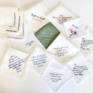K&ouml;nnte beinhalten: Eine Sammlung quadratischer Stofftaschent&uuml;cher mit individueller Stickerei in verschiedenen Farben und Schriftarten. Die wei&szlig;en und salbeigr&uuml;nen T&uuml;cher zeigen pers&ouml;nliche Nachrichten, Namen und Daten, eines mit Blumenmuster und eines mit Spitzenbesatz.