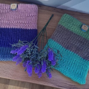May include: Two knitted neck warmers with striped patterns. One is pink, blue, and teal. The other is green, brown, and teal.