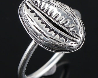 May include: A silver ring with a detailed design of a cowrie shell. The ring is made of sterling silver and has a polished finish.