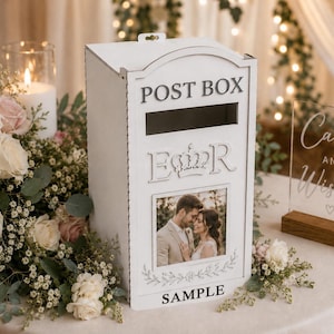 May include: A white wooden post box featuring the text POST BOX at the top, the letters E and R flanking a crown emblem in the centre, and a rectangular photo frame below containing a picture of a couple. The word SAMPLE is printed at the bottom.