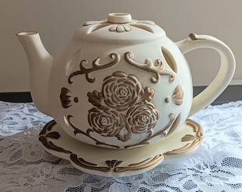 Vela decorativa con forma de tetera PartyLite / Porcelana color marfil con detalles dorados / Juego de decoración para la hora del té