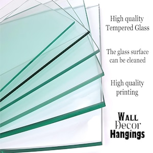 May include: Stack of clear tempered glass panels with a green tint. The glass is smooth and reflective. The text "High quality Tempered Glass" is printed on the right side of the image. The text "The glass surface can be cleaned" is printed below the first line of text. The text "High quality printing" is printed below the second line of text. The text "WALL Decor Hangings" is printed in large letters at the bottom of the image.
