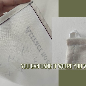 May include: A white canvas bag with a black border and a loop for hanging. The bag has the text "YOU CAN HANG IT WHERE YOU WANT" printed on it.