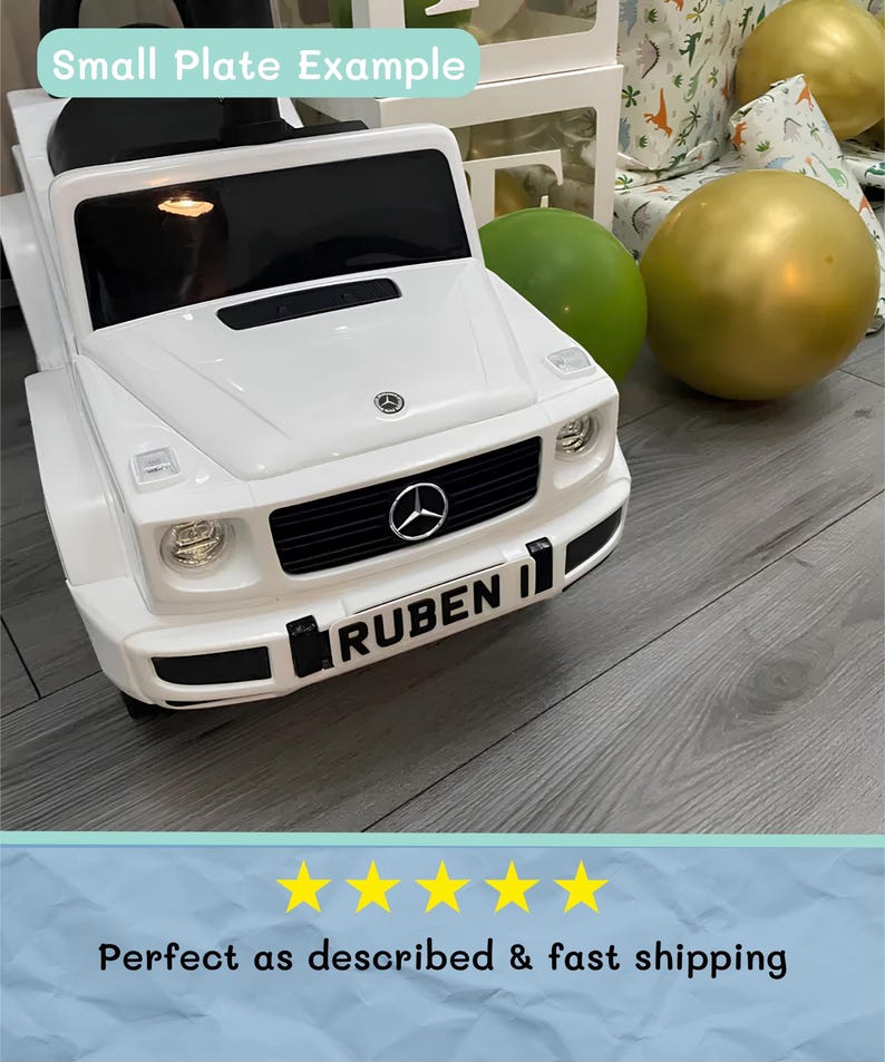 May include: A white toy car with black accents, featuring a front grille with the Mercedes-Benz logo and the name "RUBEN" on the license plate. The text "Small Plate Example" is at the top. A gold and green balloon are in the background.