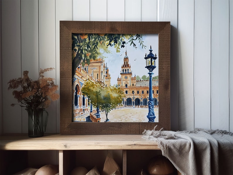 May include: A watercolour painting of a Spanish plaza with a clock tower and a street lamp. The painting is framed in a brown wooden frame and is hanging on a white wall.