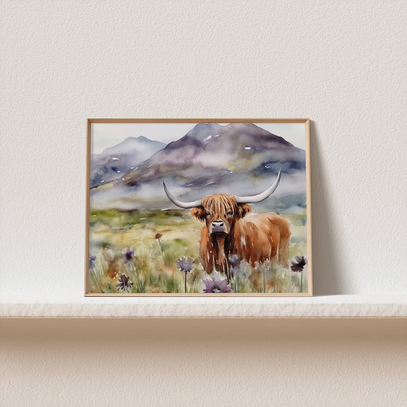 May include: Watercolor painting of a brown Highland cow standing in a field of purple wildflowers with a mountain range in the background.