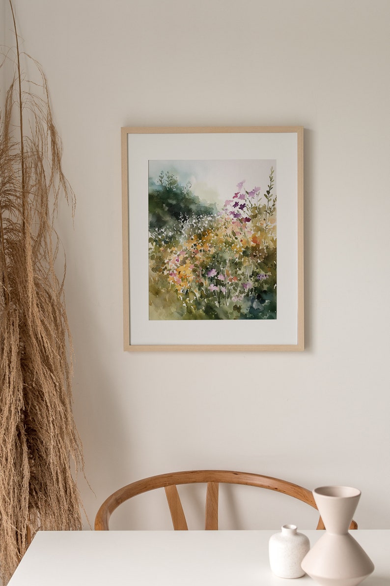 May include: A framed watercolor painting of a field of wildflowers in shades of purple, yellow, and green. The painting is set against a light background.