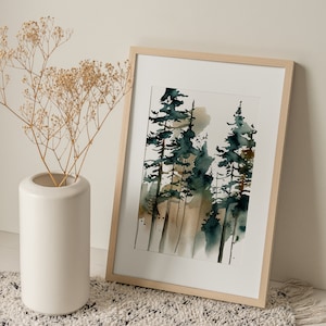 May include: Watercolor painting of a forest scene in a light wood frame. The artwork features tall, slender trees in shades of green and brown against a soft, neutral background. A white vase with dried flowers sits to the left.