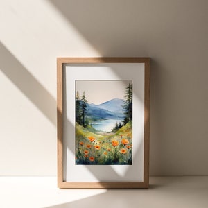 Puede incluir: Pintura acuarela enmarcada de un paisaje con un lago, monta&ntilde;as y un campo de amapolas naranjas.