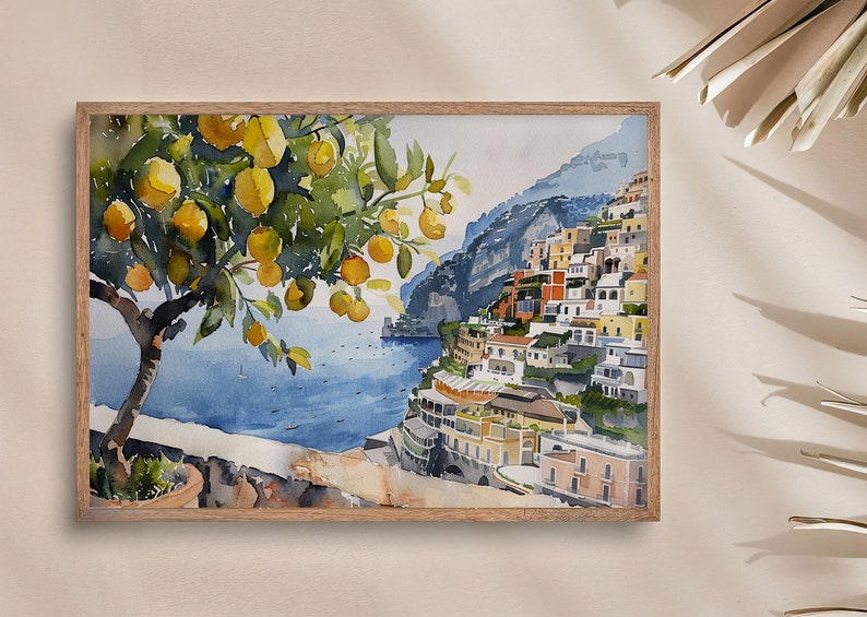 May include: Watercolor painting of a lemon tree with yellow lemons hanging from the branches. The tree is in the foreground of the painting, with a view of a colorful Italian village built into a hillside in the background. The village is on a cliff overlooking the blue sea.