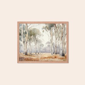 May include: A watercolour painting depicting a forest scene with tall, slender trees featuring white bark. The trees are arranged in a line, creating a sense of depth and perspective. The background is a soft, hazy blue, suggesting a distant horizon. The painting is framed in a light wood frame.