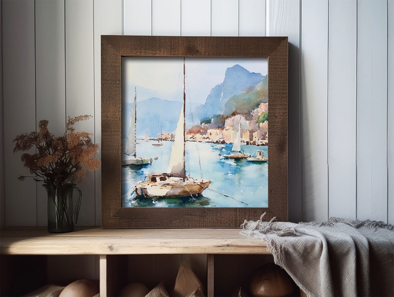 May include: A watercolour painting of a seascape with sailboats in a harbour. The painting is framed in a dark brown wood frame and is hanging on a white wall.