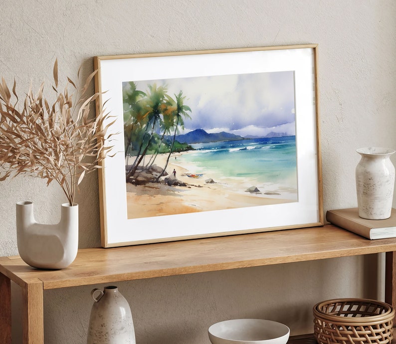 Peut inclure: Une peinture &agrave; l'aquarelle encadr&eacute;e repr&eacute;sentant une sc&egrave;ne de plage tropicale avec des palmiers, de l'eau bleue et un rivage sablonneux.