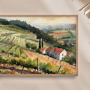May include: Watercolor painting of a vineyard landscape with rolling hills, a farmhouse with a red roof, and rows of grapevines. The artwork is framed in a light brown wooden frame, showcasing a serene countryside scene.