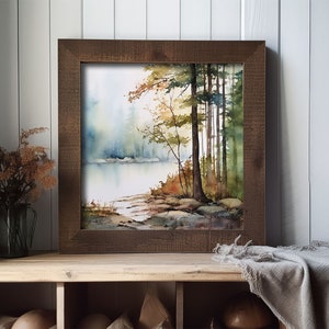 May include: A framed watercolor painting of a forest scene with a lake in the foreground. The trees are a mix of green and brown, and the water is a light blue. The painting is in a rustic wooden frame.