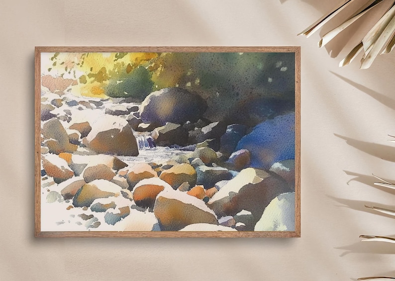 May include: Watercolor painting of a stream flowing through a rocky landscape. The water is a light blue, and the rocks are a variety of browns and grays. The painting is framed in a light wood frame.