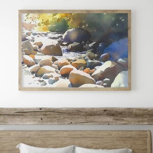 May include: Watercolor painting of a stream flowing over smooth, rounded rocks. The water is a light blue, and the rocks are a variety of colors, including brown, gray, and white. The background is a blur of green and blue, suggesting trees and foliage.