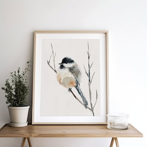 Peut inclure: Une peinture &agrave; l'aquarelle d'un petit oiseau perch&eacute; sur une branche. L'oiseau est brun, noir et blanc avec une longue queue. L'arri&egrave;re-plan est beige clair.