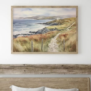 May include: A watercolour painting depicting a coastal scene with a white house perched on a hill overlooking a sandy beach and the ocean. A winding path leads to the house, with a wooden fence and green grass lining the way.
