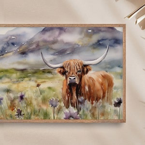May include: Watercolor painting of a Highland cow standing in a field of wildflowers. The cow is brown with long, shaggy hair and large horns. The background is a misty mountain landscape.