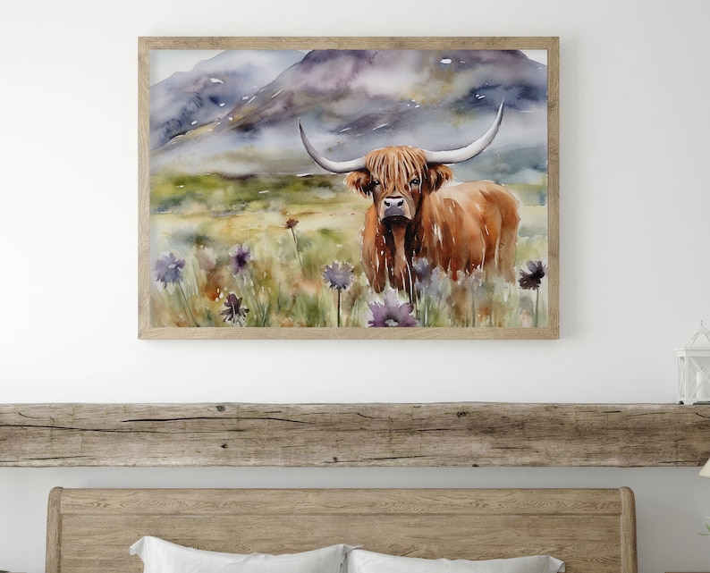 May include: Watercolor painting of a brown Highland cow standing in a field of purple wildflowers with a mountain range in the background.