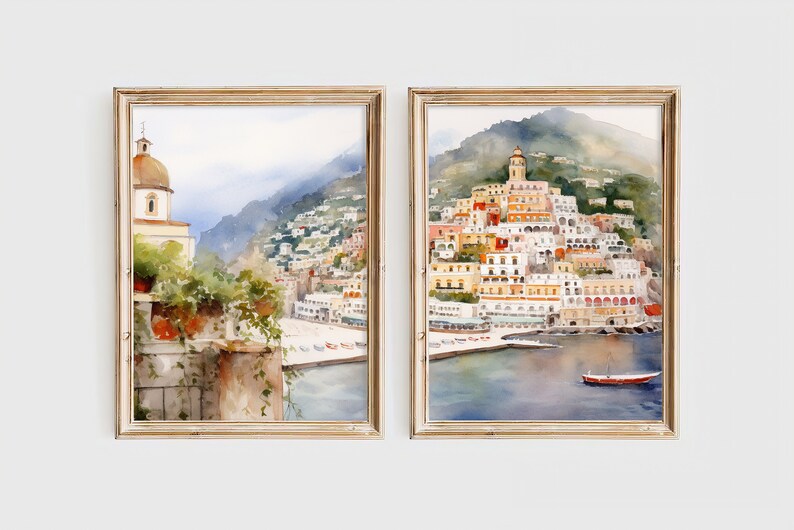 May include: Two watercolor paintings in wooden frames depicting a coastal town in Italy. The left painting shows a view from a balcony overlooking the town, while the right painting shows a wider view of the town and the sea.