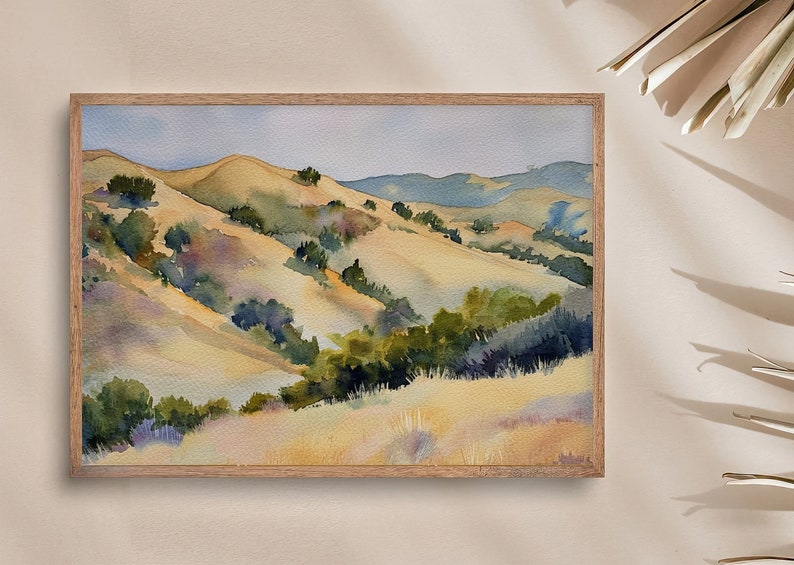 May include: Watercolor painting of a landscape with rolling hills and green trees. The hills are painted in shades of yellow, brown, and green, and the trees are a deep green. The sky is a light blue.