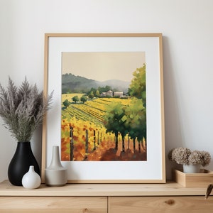 Puede incluir: Una pintura al agua enmarcada de un paisaje de vi&ntilde;edo con una granja en la distancia. La pintura presenta una hilera de vides en primer plano, con una ladera verde exuberante en el fondo. El cielo es de un azul suave con toques de rosa y naranja.
