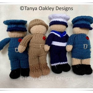 May include: Four knitted toy soldiers in different uniforms. A blue soldier, a brown soldier, a blue and white sailor, and a blue soldier with a red poppy.