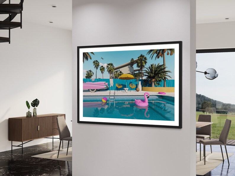 Pu&ograve; includere: Una stampa incorniciata di una casa moderna di met&agrave; secolo con una piscina. La piscina &egrave; circondata da palme e un'auto rosa. C'&egrave; un galleggiante rosa a forma di fenicottero nella piscina.