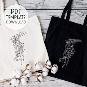 Puede incluir: Dos bolsas de tela, una blanca y otra negra, con un dise&ntilde;o de gatos colgando de palillos con fideos. El texto "PDF TEMPLATE DOWNLOAD" est&aacute; en la bolsa blanca.