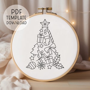 May include: A black and white line drawing of a Christmas tree made up of various Christmas icons, including a star, presents, candy canes, a bow, holly, and a snowflake. The drawing is on a white background inside a wooden embroidery hoop.