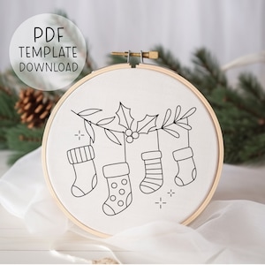 May include: A black and white line drawing of Christmas stockings hanging from a holly branch. The stockings are decorated with polka dots and stripes. The image is on a white background.