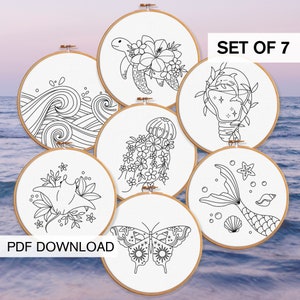 May include: Set of 7 embroidery patterns featuring ocean-themed designs. The patterns include a turtle, waves, jellyfish, a manta ray, a mermaid tail, a dolphin in a lightbulb, and a butterfly. The patterns are in black and white and are perfect for embroidery projects.