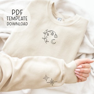 Pode incluir: Uma camisola bege com um desenho de linha preta de uma lua crescente e flores na frente e um desenho de linha preta de duas estrelas na manga. O texto "PDF TEMPLATE DOWNLOAD" est&aacute; em um c&iacute;rculo branco no canto superior esquerdo da imagem.