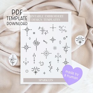 Könnte beinhalten: Eine weiße, druckbare Stickdesignvorlage mit Illustrationen von Sternen und Monden in schwarzer Tinte. Der Text auf der Vorlage lautet "Printable Embroidery Design Templates" und "Sparkles". Ein lila Herzaufkleber sagt "made by a human".