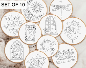 May include: Set of 10 embroidery hoop patterns featuring various designs, including a moon and sun, a dragonfly, a window with a cat, a flower, an hourglass, a planet, a snail, a cassette tape, and a stained glass window.