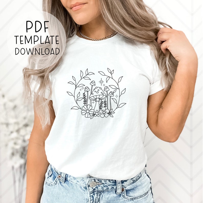 May include: White t-shirt featuring a black line drawing of mushrooms and flowers in a wreath. The text "PDF TEMPLATE DOWNLOAD" is in a circle at the top left of the image.