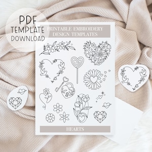 May include: Printable embroidery design templates featuring hearts with various floral and geometric designs. The designs include a heart with a key and lock, a heart with birds, a heart with flowers, and a heart with a daisy. The text "Printable Embroidery Design Templates" and "Hearts" are also included.